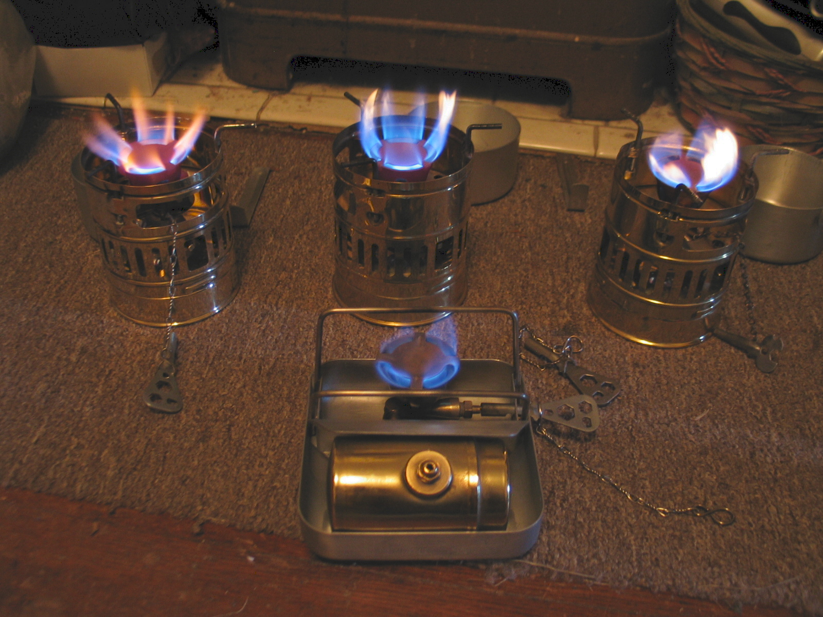 A small backpacking stove boiling water on a rock outdoors